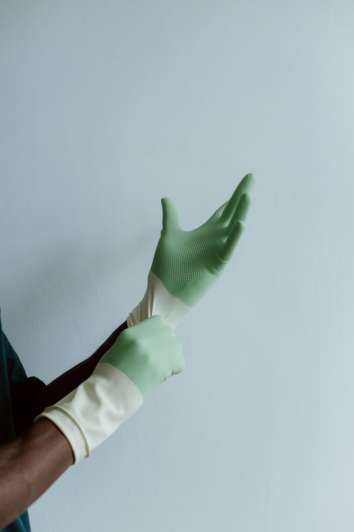 Crafting Captivating Headlines: Your awesome post title goes here A person wearing green latex gloves, ready for cleaning tasks, with space for text.